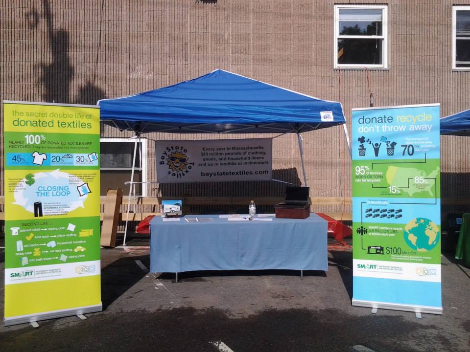 A blue tent with two banners and a table