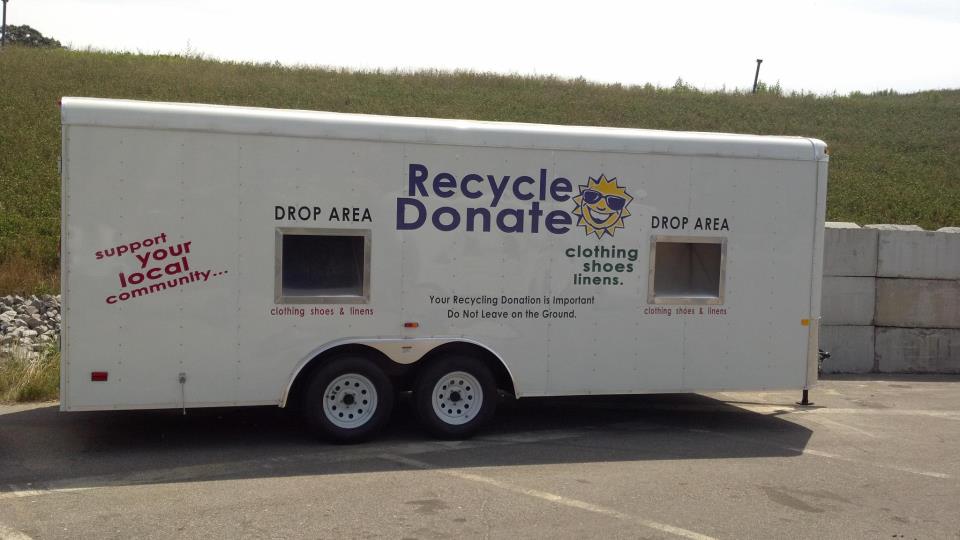 A white trailer with the words " recycle donate " on it.